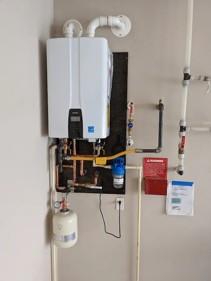 Professional plumber installing copper piping in a West New York home